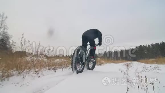 专业的极限运动员骑自行车在户外骑胖自行车。 后轮的近距离观察。 冬天骑自行车