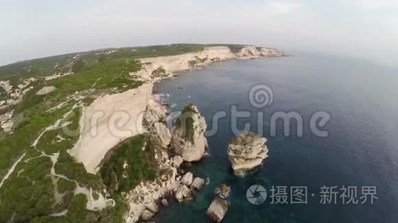 日落时分飞越博尼法西奥湾地区。 岩石和海洋。 科西嘉，法国。 空中观景。