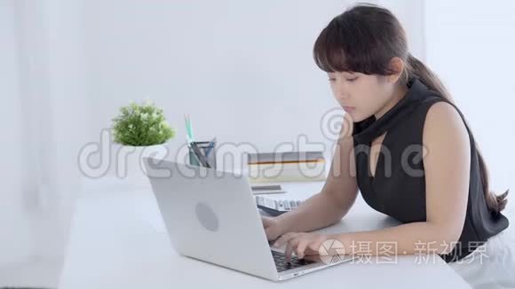 美丽的肖像自由职业年轻的亚洲妇女微笑和快乐的工作在线笔记本电脑成功与兴奋的客厅