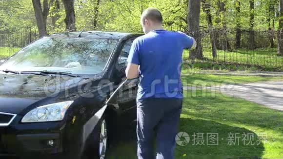 工人在室外用高压水设备清洗黑车