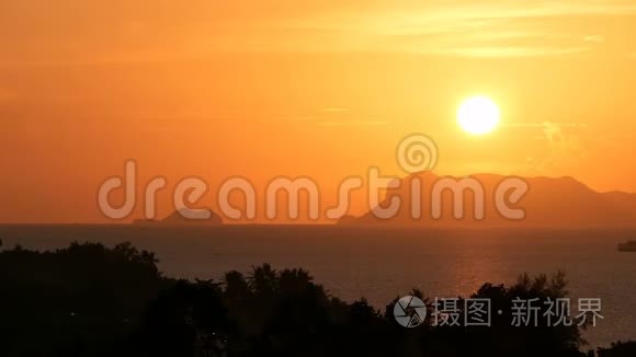 雄伟的热带橙色夏季，夕阳在海面上，群山的轮廓。 戏剧性黄昏的空中景色