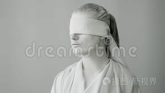 穿着石像服装的女人。 一只手握着天平的白色背景上的正义女神Femida