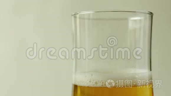 把啤酒倒进白底玻璃杯里