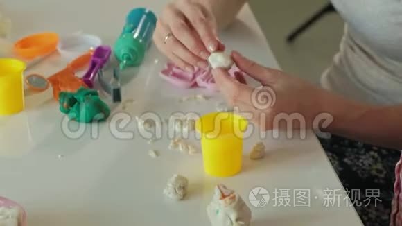 一个年轻的女人和一个女孩用塑料制成牙齿，把牙齿插入玩具下巴，扮演一个牙医，母亲和