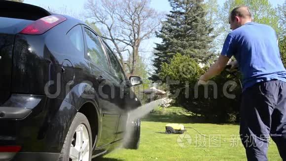 夏季工人用强力喷水冲洗汽车