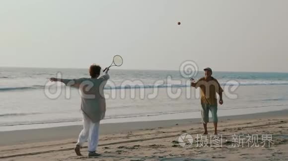 活跃的老夫妇在海滩上打太极球。