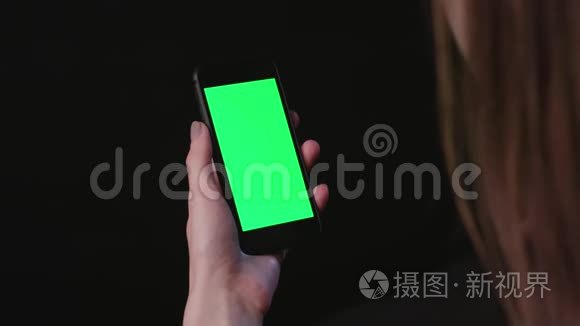 女人拿着手机，绿色屏幕轻敲