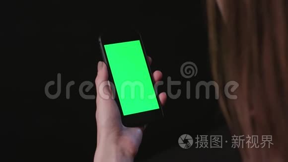 女人拿着手机，绿色屏幕轻敲