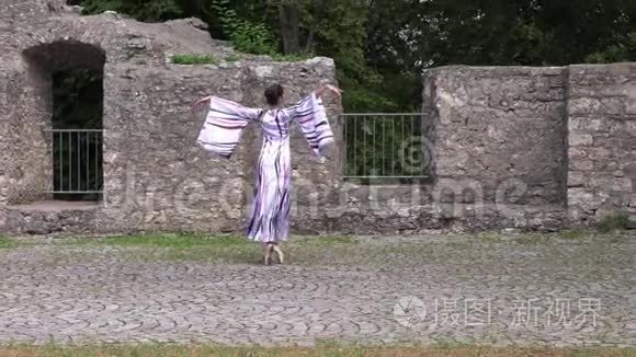 芭蕾舞演员在一座古堡遗址附近的大自然中翩翩起舞