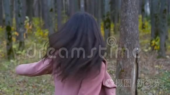 女人在秋天的公园里散步