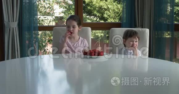 可爱的孩子在家吃新鲜成熟的草莓