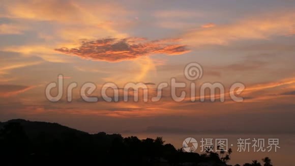 雄伟的热带橙色夏季，夕阳在海面上，群山的轮廓。 戏剧性黄昏的空中景色