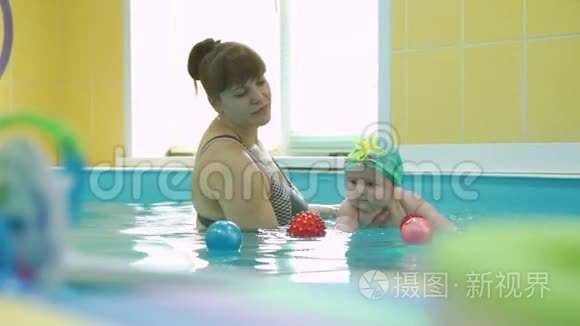 游泳教练与可爱的婴儿在游泳池