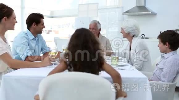 一家人坐在餐桌上品尝美食