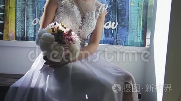 美丽的金发碧眼，穿着一件白色的新娘礼服，靠近一扇窗户，放着一束鲜花