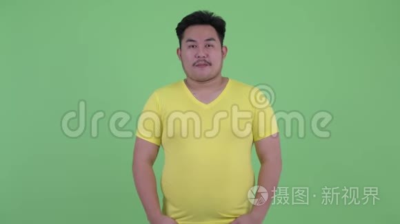 快乐的年轻超重的亚洲男人微笑