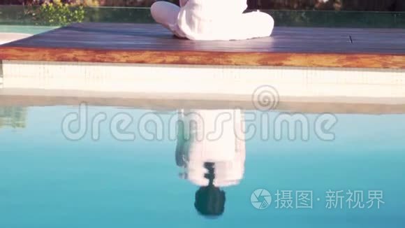 冷静的女人在泳池边做瑜伽