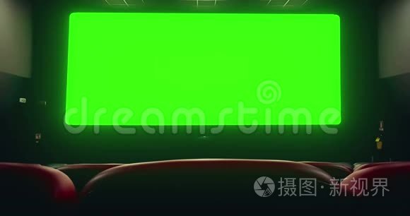电影院内部有空的红色座位，在色度键绿色屏幕上有共空间，边缘发光