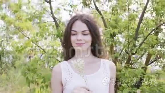 年轻漂亮的女人开着白色的草花视频