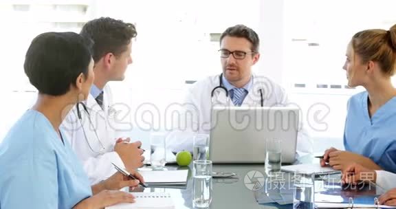 医生在会议期间和他的员工交谈