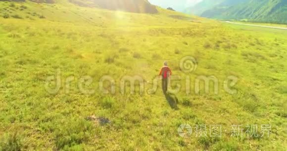 飞行背包徒步旅行游客走过青山野。 夏日的乡村山谷。