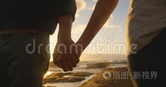 两个人手牵手走在海滩上视频