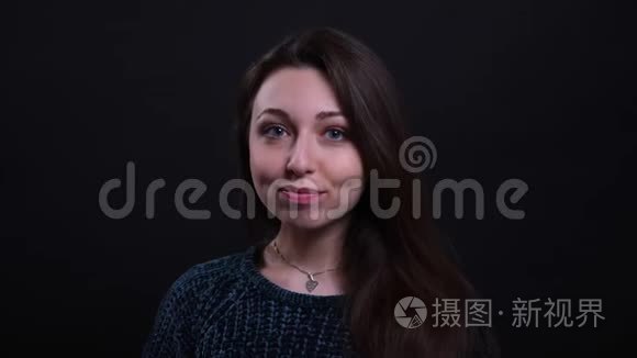 成年白种人深色头发美丽的白种人女性的特写镜头欢快地看着背景镜头