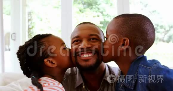 儿子和女儿在客厅亲吻父亲视频