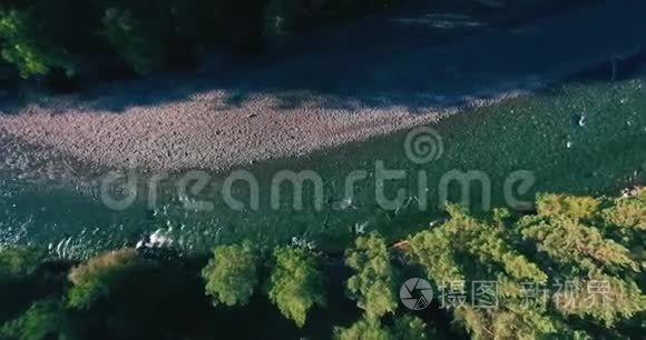 在阳光明媚的夏季早晨，低空飞行在带岩石的新鲜快山河上。