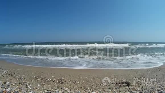 浅水中的海波流到黑海滩上视频