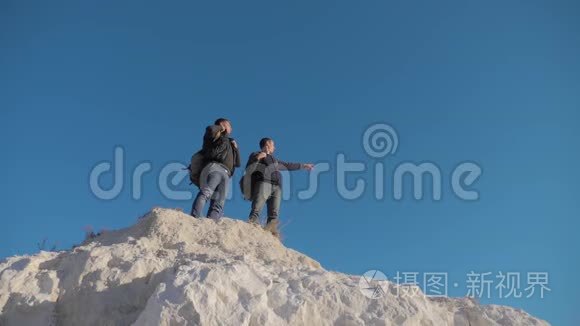 两个人游客徒步探险登山者爬山。 慢动作视频。 徒步旅行者登上顶峰赢得胜利