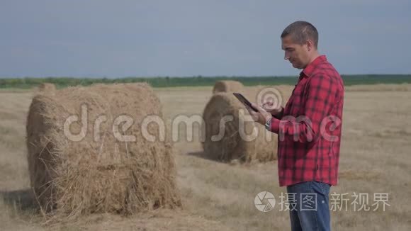 智慧农业理念.. 一名农民工人在数字平板电脑上的田野里研究一种生活方式。 慢慢