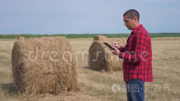 智慧农业理念.. 男子工人农民在数字平板电脑上的生活方式领域研究干草堆。 慢慢慢慢