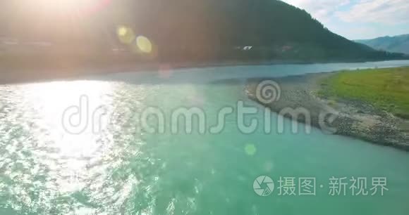 在阳光明媚的夏季早晨，低空飞行在带岩石的新鲜快山河上。