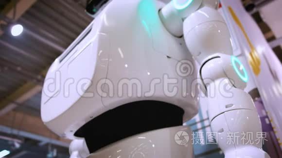 现代机器人技术。 一个人和一个机器人交流，把一个塑料机械手臂按到机器人身上，握手。