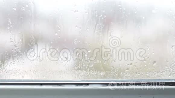 雨滴顺着窗户上的玻璃流下来