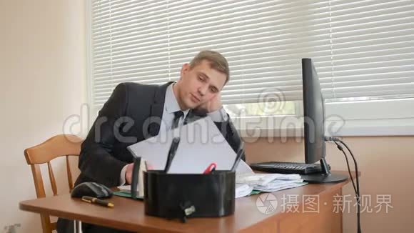 办公室的经理坐在桌边，厌倦了工作