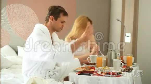 年轻夫妇在公寓的床上吃早餐视频
