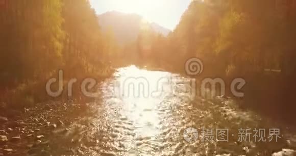 在阳光明媚的夏季早晨，低空飞行在带岩石的新鲜快山河上。