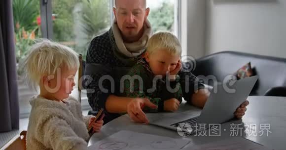 父亲和孩子在家使用笔记本电脑视频