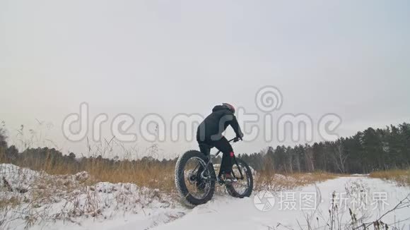 专业的极限运动员骑自行车在户外骑胖自行车。 后轮的近距离观察。 冬天骑自行车