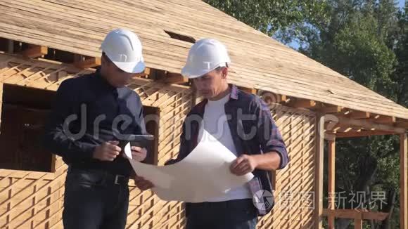团队合作。 概念建设构建建筑师慢动作视频。 两个戴头盔的男人生活方式建设者握手