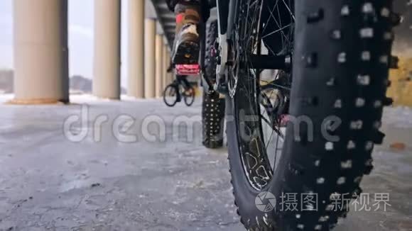 专业的极限运动员骑自行车在户外骑胖自行车。 后轮的近距离观察。 冬天骑自行车