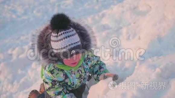 一个小孩子正在冬天的公园里玩雪。 晴朗的冬日。 新鲜空气中的乐趣和游戏。