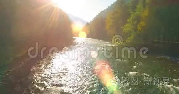 在阳光明媚的夏季早晨，低空飞行在带岩石的新鲜快山河上。