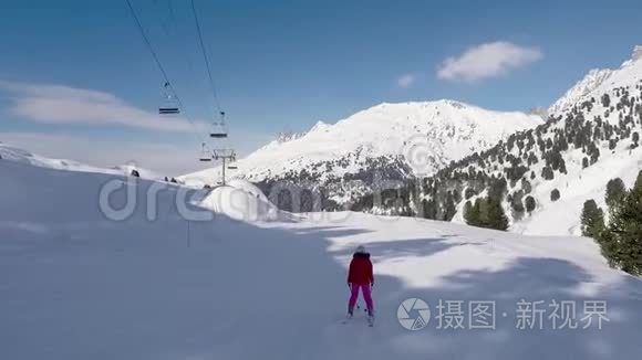 在晴朗的一天，滑雪者在冬季山区的滑雪坡上滑雪