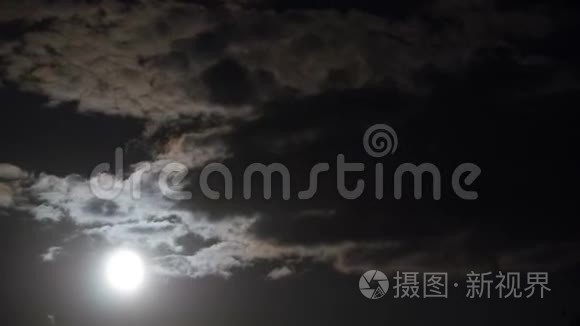 满月通过乌云在夜空中移动。 时间流逝