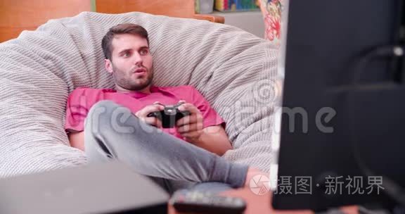 穿睡衣的男人玩电视游戏视频