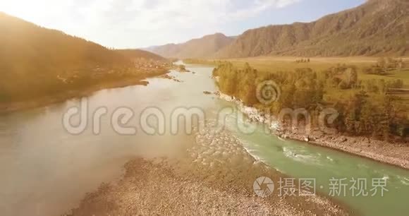 在阳光明媚的夏季早晨，低空飞行在带岩石的新鲜快山河上。