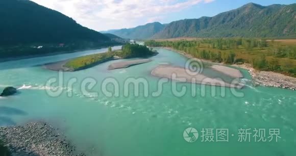 在阳光明媚的夏季早晨，低空飞行在带岩石的新鲜快山河上。